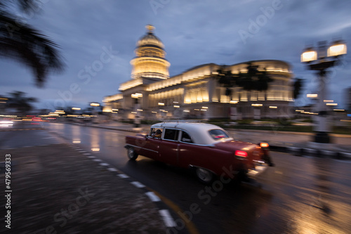 Old car on streets of Havana with Capitolio building in background with reflection on rain time. Cuba © danmir12