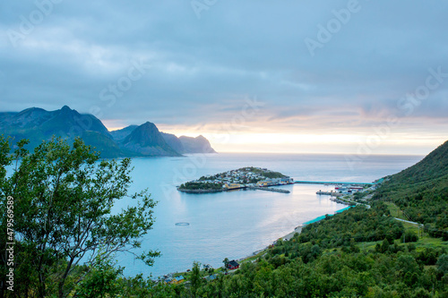 Aerial view of Husoy, little village on a tiny island belonging to the large island of Senja and being surrounded by beautiful mountain landscape.