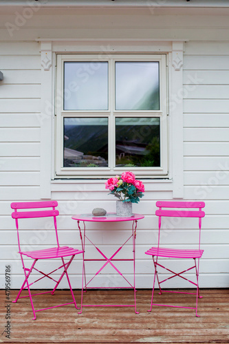 pink table with two chairs on a terrace in Husoy, little village on a tiny island belonging to the large island of Senja and being surrounded by a beautiful  landscape photo