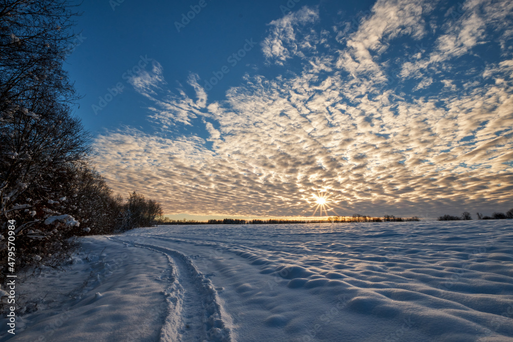 blue sky with snow and clouds and foot trails