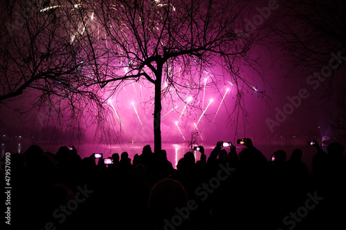 People watch fireworks and a laser show over the lake during New Years celebrations in the Alexandru Ioan Cuza park in Bucharest. photo