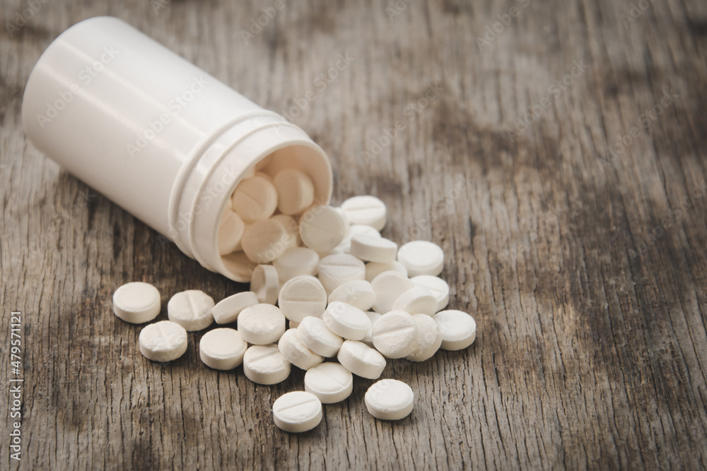 Narcotic pills on a wooden table close Narcotic pills on a wooden table close