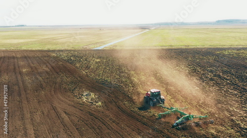 4K Aerial Elevated View.Tractor Plowing Field. Beginning Of Agricultural Spring Season. Cultivator Pulled By A Tractor In Countryside Rural Field Landscape © Grigory Bruev