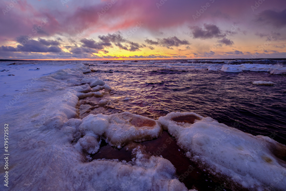 sunset in winter small river frozen snow in the beach