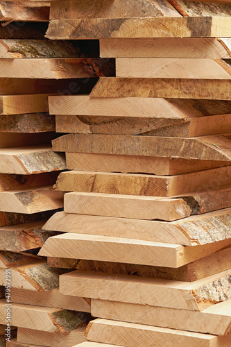 Vertical photo of a large pallet of rough wood planks.