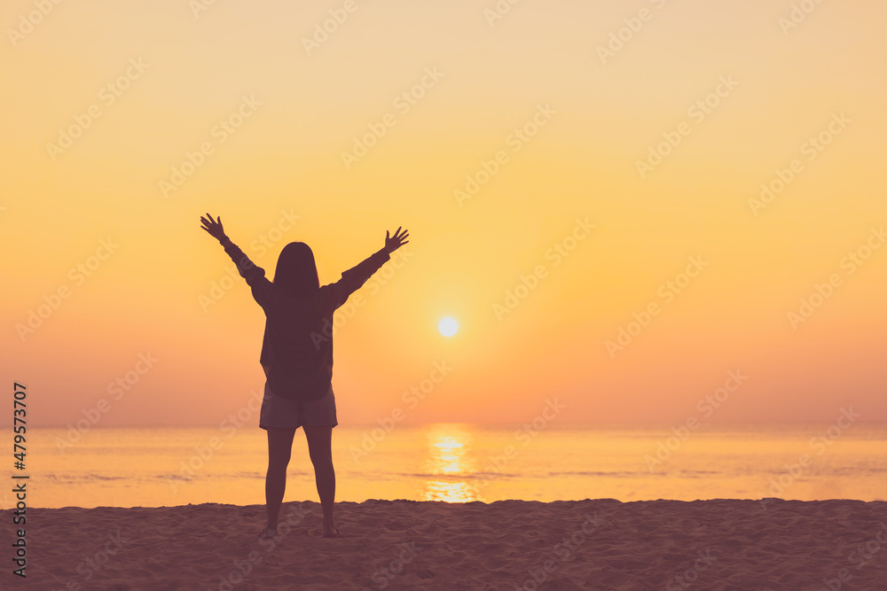 Copy space of woman rise hand up on sunset sky at beach and island background.