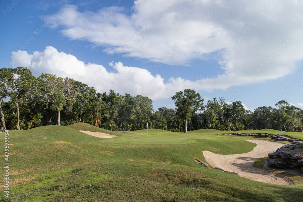 Fototapeta premium Golf course with gorgeous green and pond. View of a beautiful green golf course