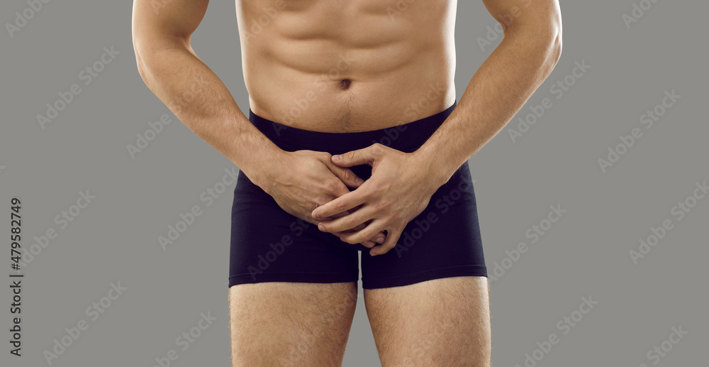 Man in underwear standing isolated on grey background covering his painful  crotch area. Cropped shot, banner. Male intimate health problems, sexually  transmitted diseases, testicular cancer concept Photos