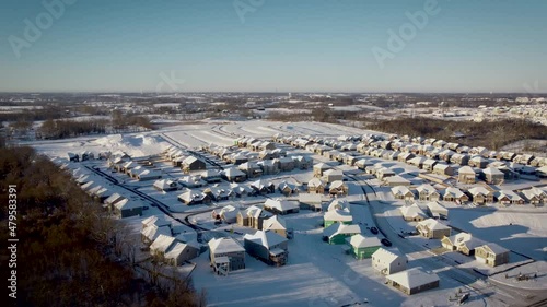 Flying over expanding neighborhood with houses in different stages of the building process. Heavy machinery is preparing grounds of the next subdivision photo