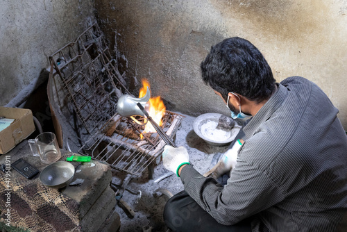 man repairing arabic coffee dalleh photo