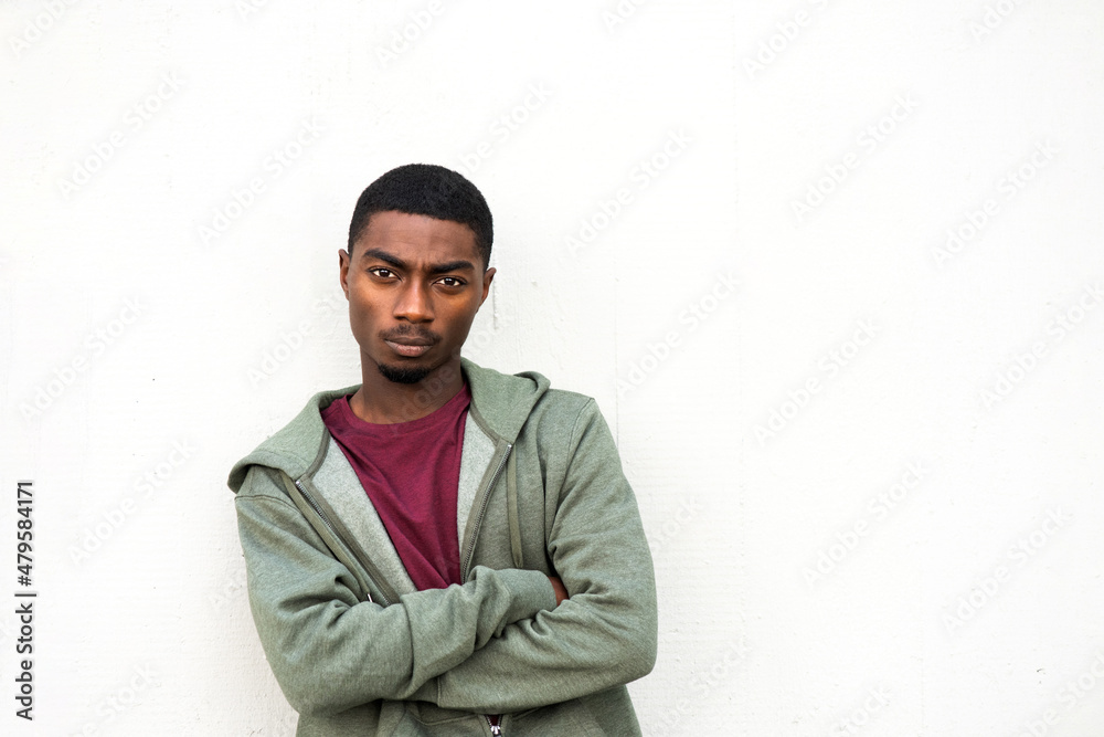 Obraz premium handsome young black man posing with arms crossed by white background