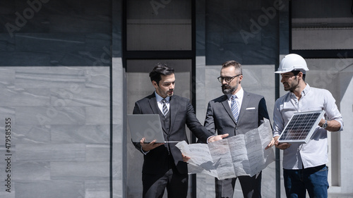 businessman or owner meeting building consults engineering team design of the building solar cell system or energy engineer plan project under construction. clean and green alternative energy concept.