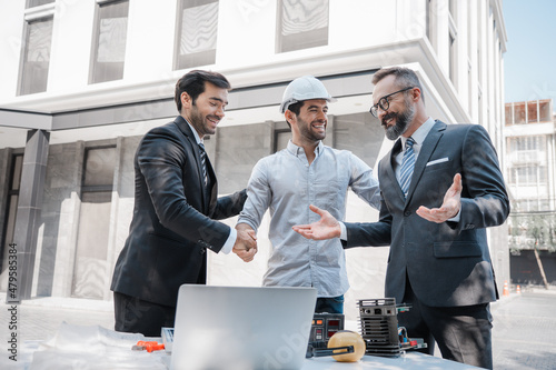 Diverse Team of Specialists Use Laptop Computer on Construction Site. Consultant present innovation for Building Project with Civil Engineer, Architectural Investor, Businessman and Worker Discussing