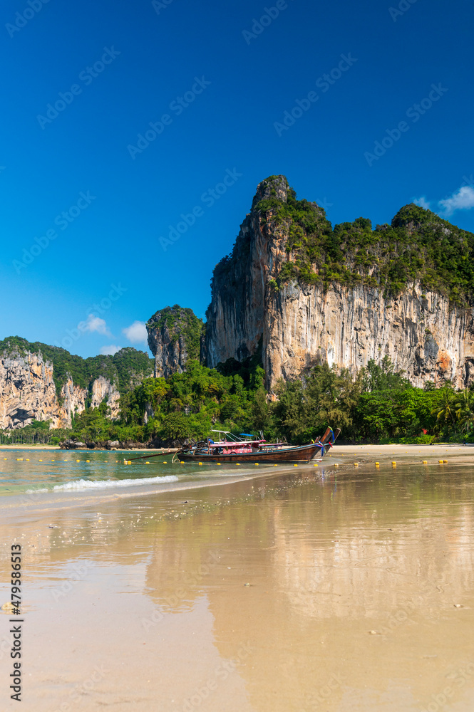 beautiful reflection of natural mountain and Longtail boat on send beach Railay Beach, in Krabi, Ao Nang, Thailand. -summer day
