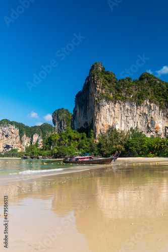 beautiful reflection of natural mountain and Longtail boat on send beach Railay Beach, in Krabi, Ao Nang, Thailand. -summer day