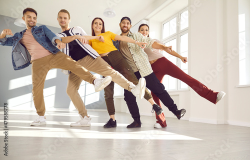 Foto Happy dancers posing for a photo standing in a row on one leg