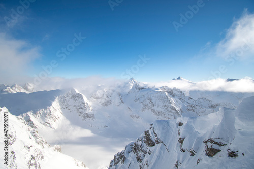 snow-capped mountains in the Swiss Alps under blue winter skies © Cristina