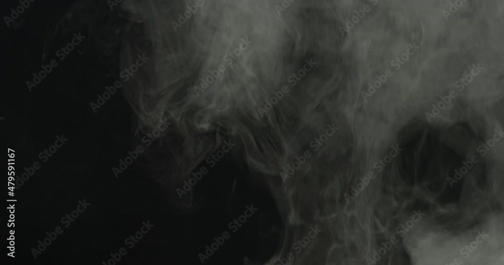 Realistic atmospheric gray smoke on black background. White fume slowly floating rises up.
