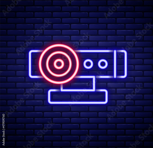 Glowing neon line Web camera icon isolated on brick wall background. Chat camera. Webcam icon. Colorful outline concept. Vector