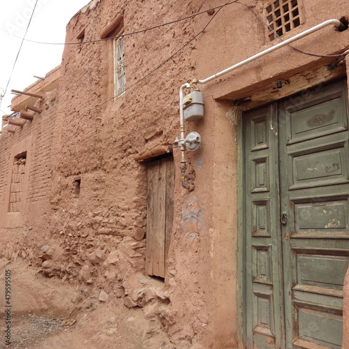 gas meter in front of the green door and reddish wall at Abyaneh village Iran