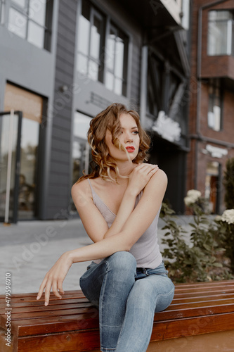 Girl with beautiful hairstyle posing outdoors. Woman in the city