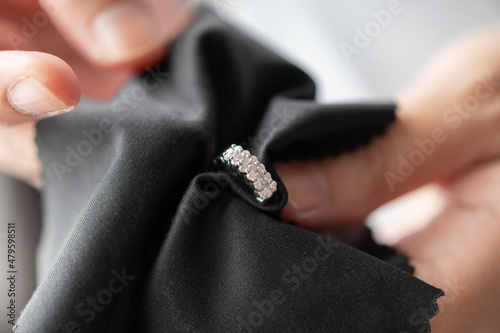 Jeweller cleaning jewelry diamond earrings with fabric cloth