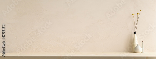 Decorative vase with dry flowers on a table against bright brown stucco wall in the room. Mockup.	
 photo