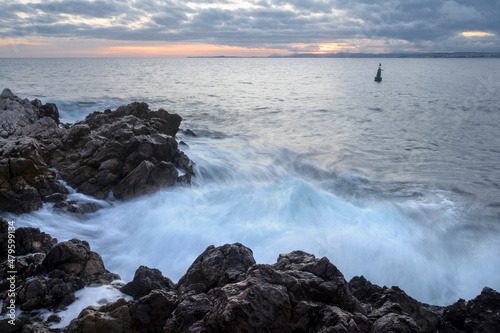 Paysage marin du rivage méditerranéen au Cap de Nice en hiver avec des vagues et des rochers au coucher du soleil