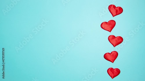 Red hearts on a blue background. Valentine's day concept. Stop motion animation.