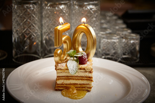 Anniversary. Cake with candles and the number 50.