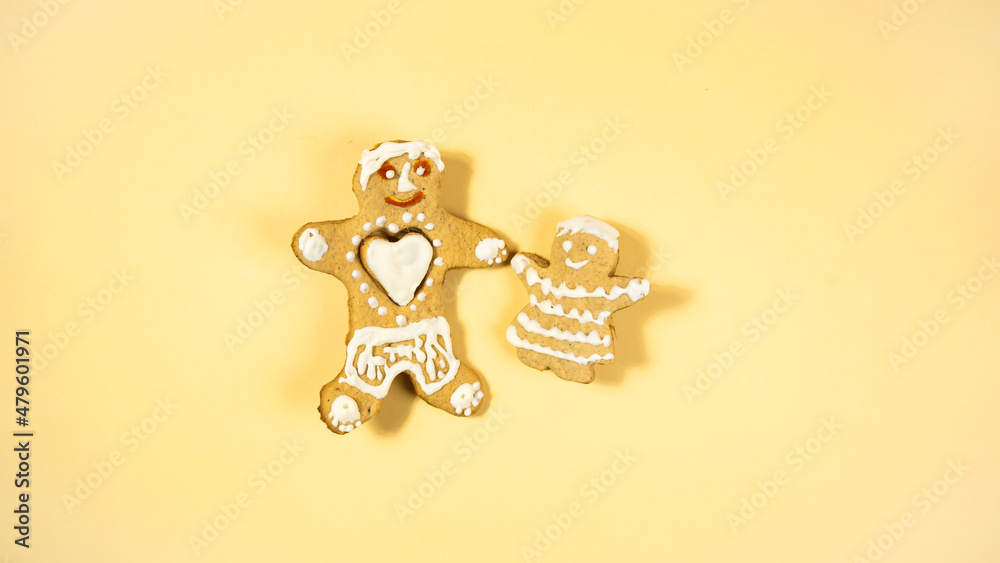 Two gingerbread man. Gingerbread made by children. Big white heart in the chest of a man. Homemade cookies. Two gingerbread man. Gingerbread made by children. Big white heart in the chest of a man. Homemade cookies.
