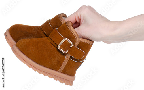 Kids brown winter boots in hand on white background isolation