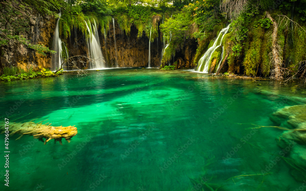 Naklejka premium Last sunlight lights up the pure water waterfall on Plitvice National Park. Colorful spring panorama of green forest with blue lake. Great countryside view of Croatia, Europe.