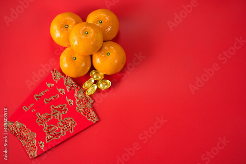 flatlay design for chinese new year concept with red envelope orange and gold on red background