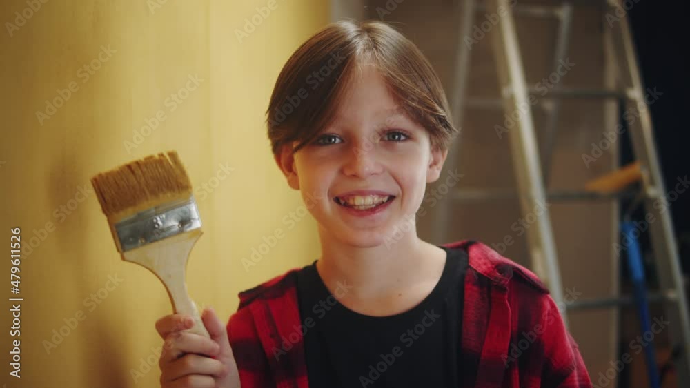 Happy boy portrait, child posing on painted wall background, holding paintbrush, making overhaul. Doing renovating with kid. Interior design, new apartment. Happy boy portrait, child posing on painted wall background, holding paintbrush, making overhaul. Doing renovating with kid. Interior design, new apartment.