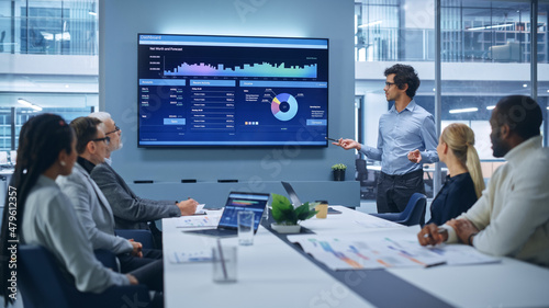 Fotografia Office Conference Room Meeting Presentation: Latin Businessman Talks, Uses Wall TV to Show Company Growth with Big Data Analysis, Graphs, Charts, Infographics