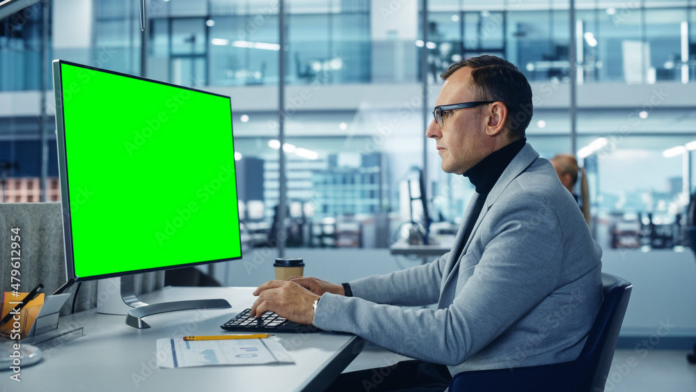 Diverse Corporate Office: Stylish Handsome Big Data Engineer Using Desktop Computer with Green Chroma Key Screen. Businessman Working on e-Commerce Project Marketing, Development.