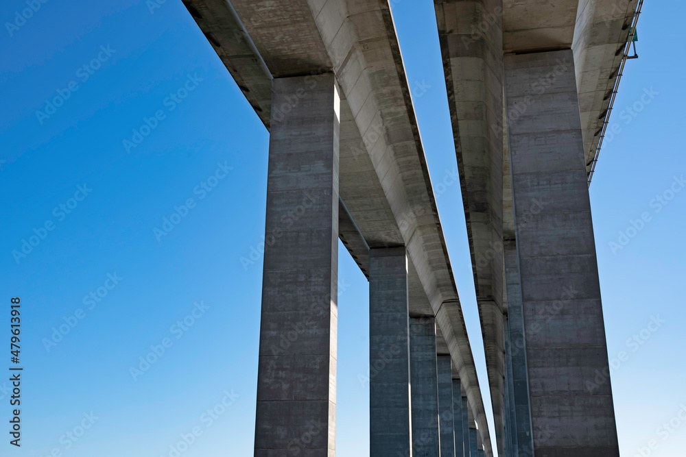 Two-lane expressway bridge with tall pillars against a blue sky, with copy space. Two-lane expressway bridge with tall pillars against a blue sky, with copy space.