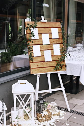 Wedding wooden Board Mockup easel with welcome sign decorated with flowers, outdoors. Greeting card template. Selective focus