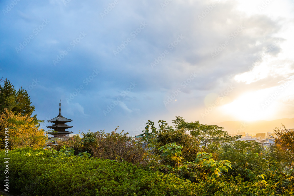 The top of the Yasaka-no-to Pagoda at the Hōkan-ji Temple with the sun piercing the storm clouds in Kyoto, Japan.