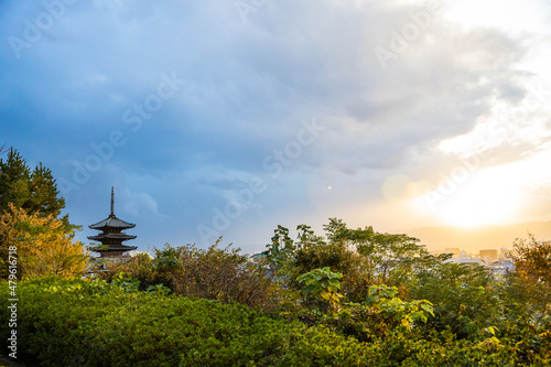 The top of the Yasaka-no-to Pagoda at the Hōkan-ji Temple with the sun piercing the storm clouds in Kyoto, Japan. photo
