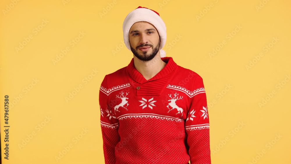 smiling man in santa hat and red sweater isolated on yellow smiling man in santa hat and red sweater isolated on yellow