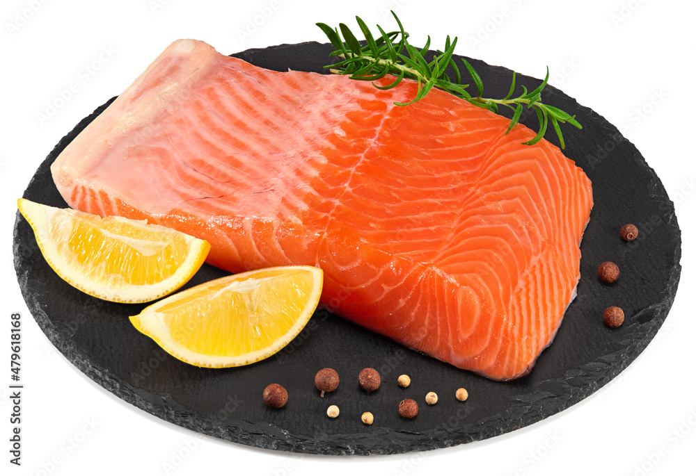 Red fish. Raw salmon fillet with rosemary, peppercorns and lemon on black round stone plate isolate on white background. Clipping path and full depth of field Red fish. Raw salmon fillet with rosemary, peppercorns and lemon on black round stone plate isolate on white background. Clipping path and full depth of field