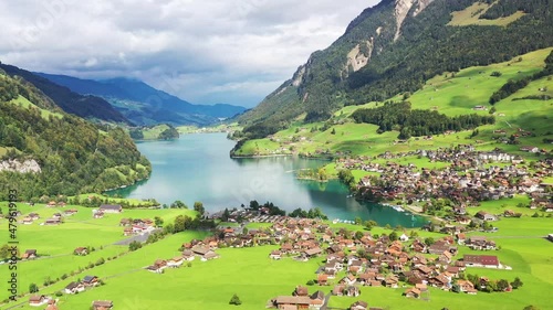 A village Lungern in Switzerland. Field  and houses. A sunny day and a mountain valley. Landscape from drone.