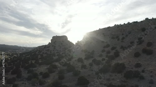 Sun shines behind a rocky hill in New Mexico