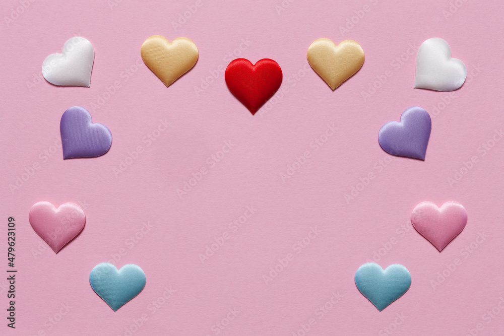 Valentine day background of many different colorful textile hearts on pink soft background. Copy space.