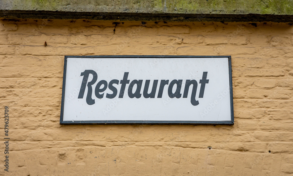 Restaurant sign on an old building with beige coloured facade Restaurant sign on an old building with beige coloured facade