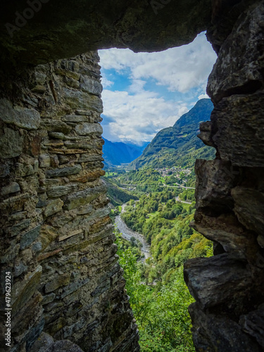 View through a medieval window of a castle on a valley in Switzerland, San Bernardino road