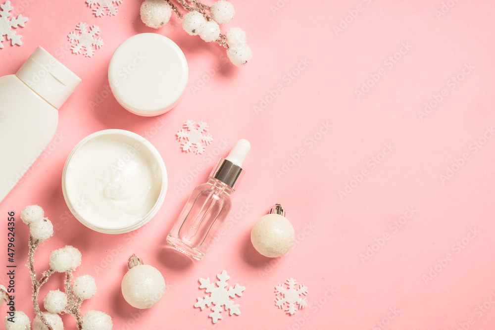Leinwandbild Motiv - nadianb : Winter cosmetic, skin care product. Cream, serum, tonic with winter decorations. Top view on pink background with copy space.