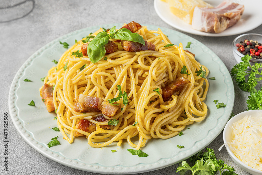 Classic homemade pasta carbonara with spaghetti, pancetta, egg, parmesan cheese on gray table. close up